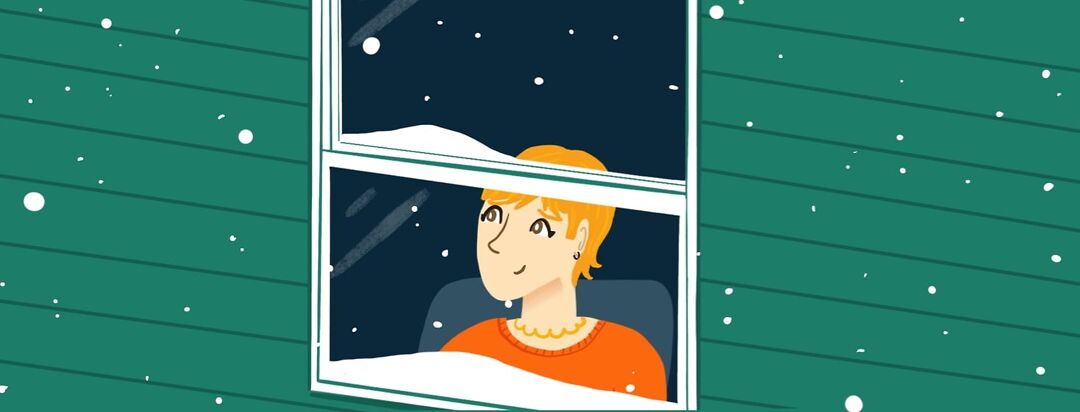 A woman with a small smile looking out of a frosty window looking at falling snow