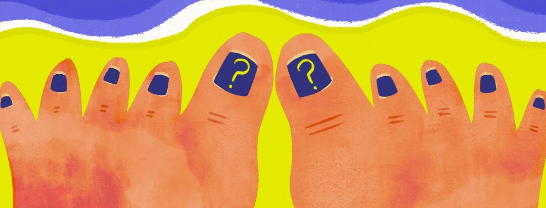 A pair of feet in the sand with psoriasis and a pedicure of question marks