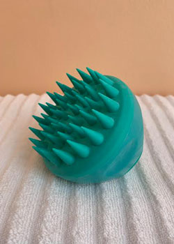 three quarter view of a small round scalp brush