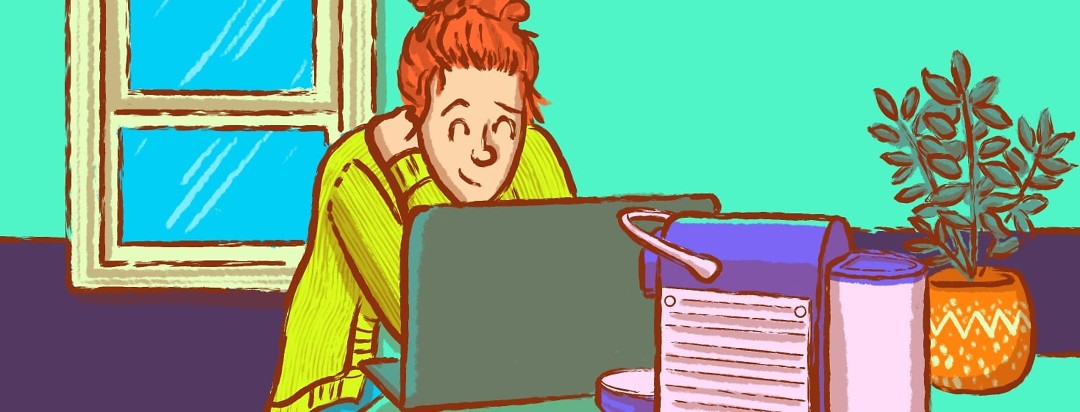 A happy content and comfortable woman smiling while standing at her kitchen counter working from home on her laptop.