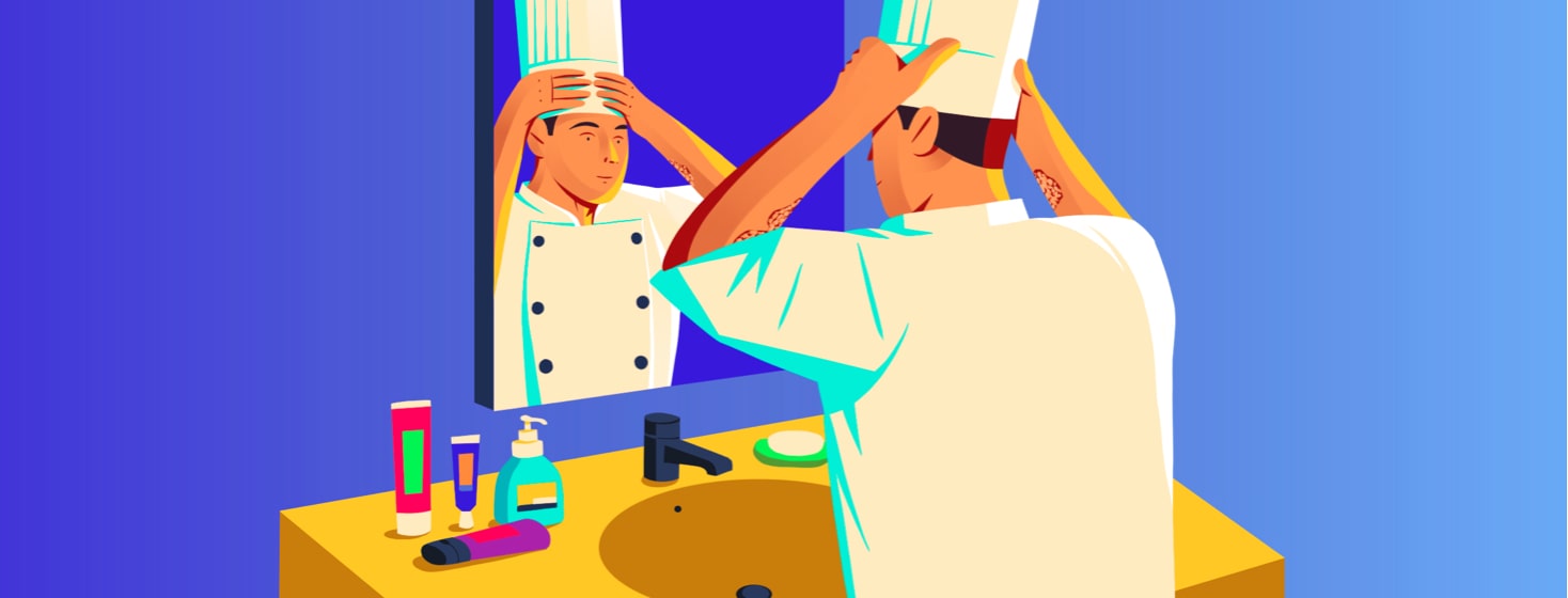 alt=a chef places his hat on his head while looking in a bathroom mirror during his daily routine.